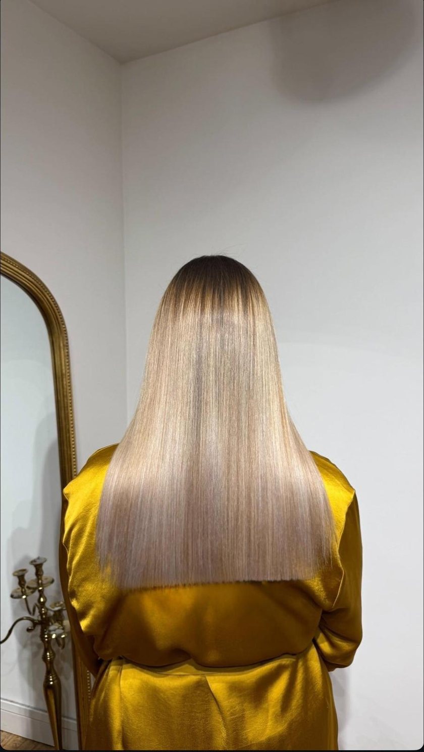 Cheveux blonds longs lisses et lumineux après le lissage